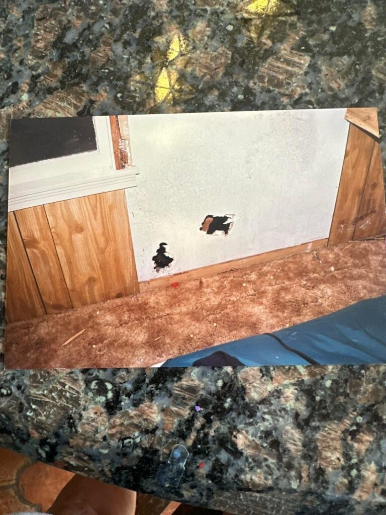 Crime scene photo from the Rebecca Beard case showing two holes inside the Clute residence where investigators said she was shot.