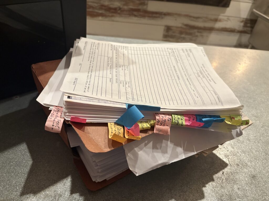 Stack of police reports, court records, and investigative documents marked with colorful tabs reviewed by Rebecca Beard’s family as they search for answers in the decades-old cold case.