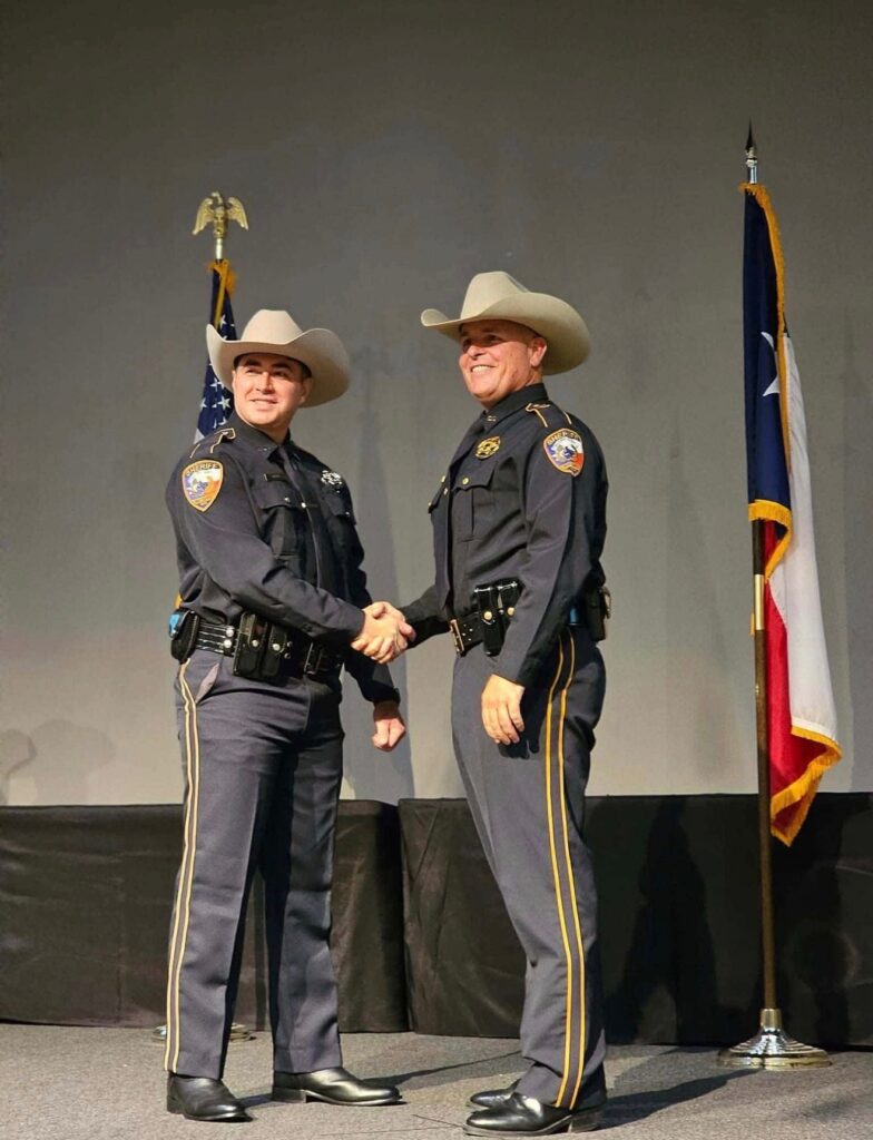 Deputy Kevin Tippit shakes hands with Brazoria County Sheriff Bo Stallman during a law enforcement ceremony.