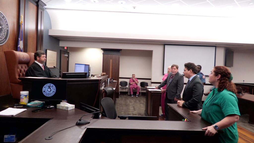 James Elmore Jr. stands with attorneys before Judge Jeth Jones in the 122nd District Court in Galveston County.