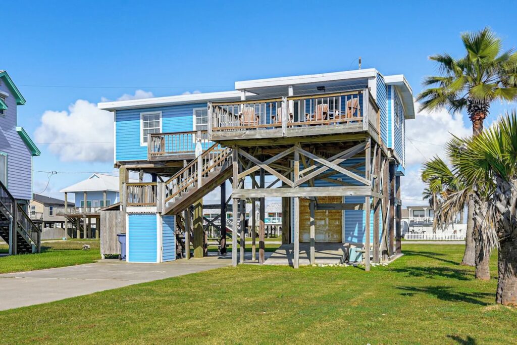 Beach house rental in Brazoria County, Texas, with palm trees and a raised coastal-style home.