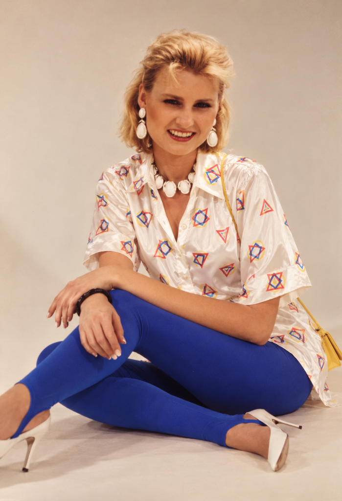 Recreation of Rebecca “Becky” Beard wearing a white patterned top, bright blue pants and white heels, depicting her reported outfit on the night she disappeared in 1986.