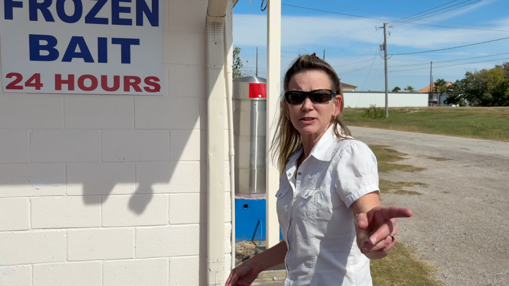 Renee stands outside a convenience store in Texas, pointing toward the area where she recalls encountering three men in a vehicle in 1979.